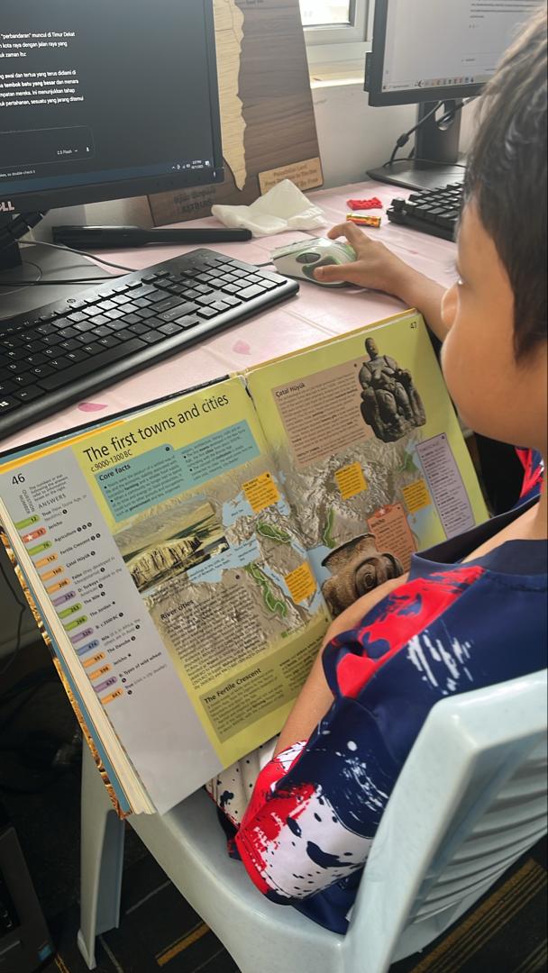 Pelajar membaca buku sejarah semasa sesi pembelajaran